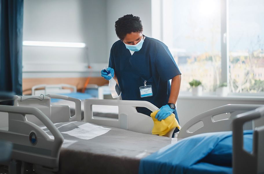 Agent nettoyant un lit d'hopital